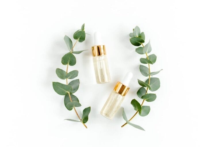 two bottles of oil next to a green plant